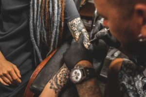 Close-up of hands and tattoo machine